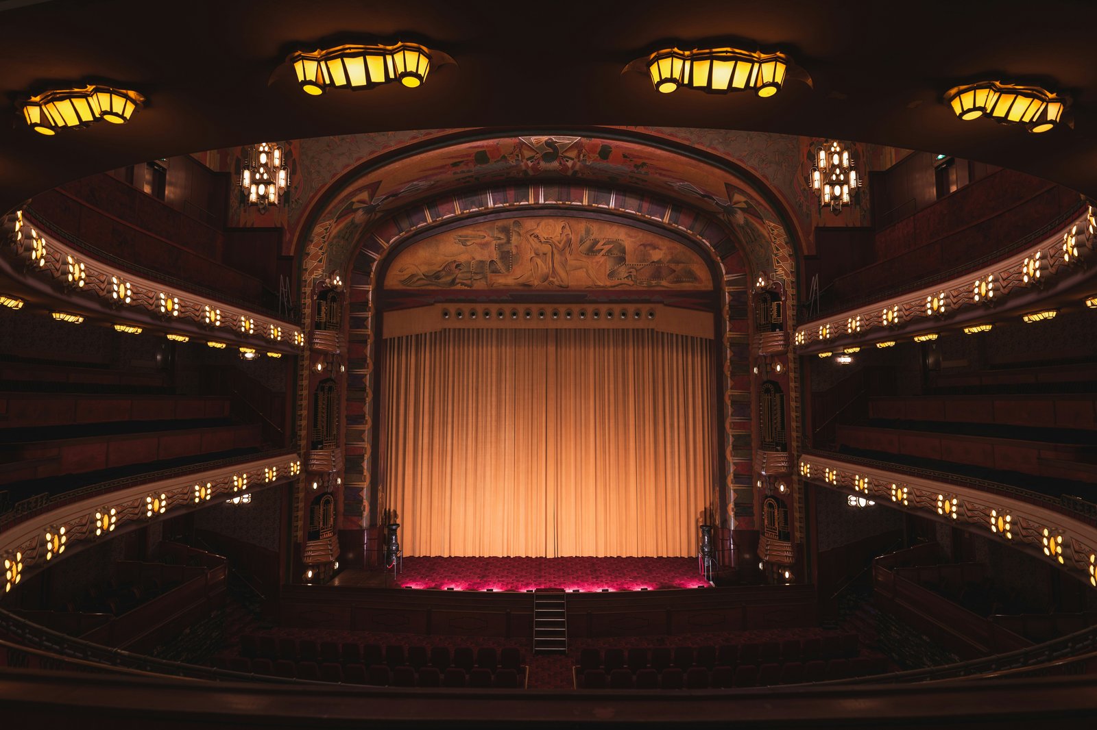 Grand West End theatre interior with stage curtain